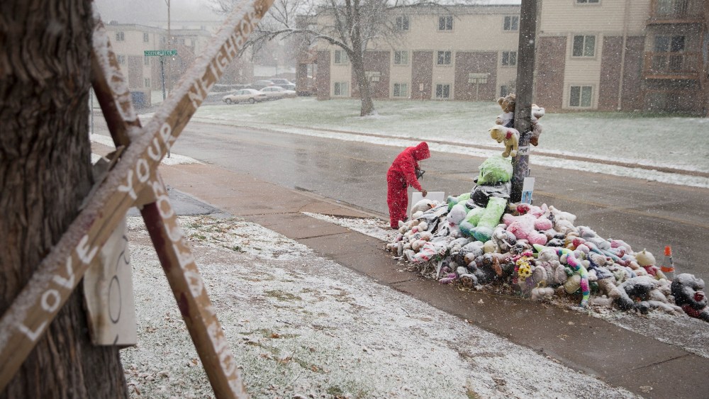 Chris Seltzer cleans the area around a memorial near the location where 18-year-old Michael Brown was shot, Nov. 16, 2014 in Ferguson, Mo. (Scott Olson/Getty)