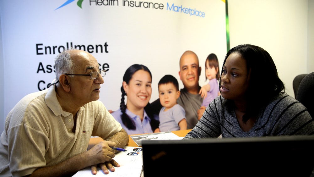 Narendra Parmar sits with Certified Enrollment Specialist, Laquanda Jordan, as he finishes the process of picking and signing up for health insurance in Miami, Dec. 23, 2013.