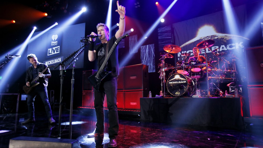 (L-R) Ryan Peak, Chad Kroeger and Daniel Adair from the band Nickelback perform at iHeartRadio Theater on Nov. 18, 2014 in Burbank, Calif. (Photo by Mike Windle/Getty for iHeartMedia)