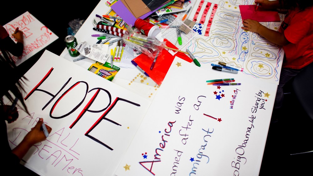 Attendees make signs at the offices of 32BJ SEIU, a workers union, during a viewing party for U.S. President Barack Obama's speech on evecutive action immigration policy reform on Nov. 20, 2014 in New York City. (Photo by Kevin Hagen/Getty)