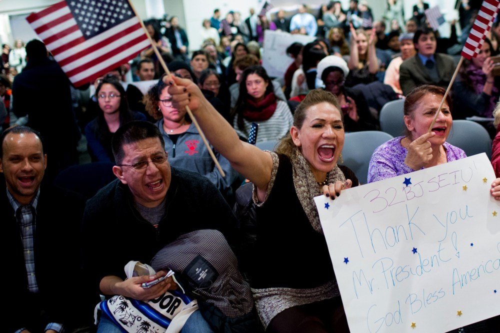 Lilian Aguayo (L), Fadila Mrkulic and Tatiana Lambert hold signs and wave flags during a viewing party for resident Barack Obama's speech on executive action immigration policy reform on Nov. 20, 2014 in New York, N.Y. (Photo by Kevin Hagen/Getty)
