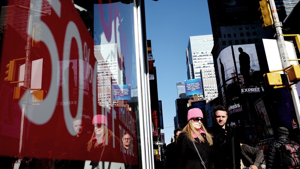 People walk past a store displaying a discount sign in Times Square in New York on Nov. 21, 2014. The National Retail Federation said last month it expects overall holiday sales this year to rise to $616.9 billion, a 4.1 percent increase from last year's