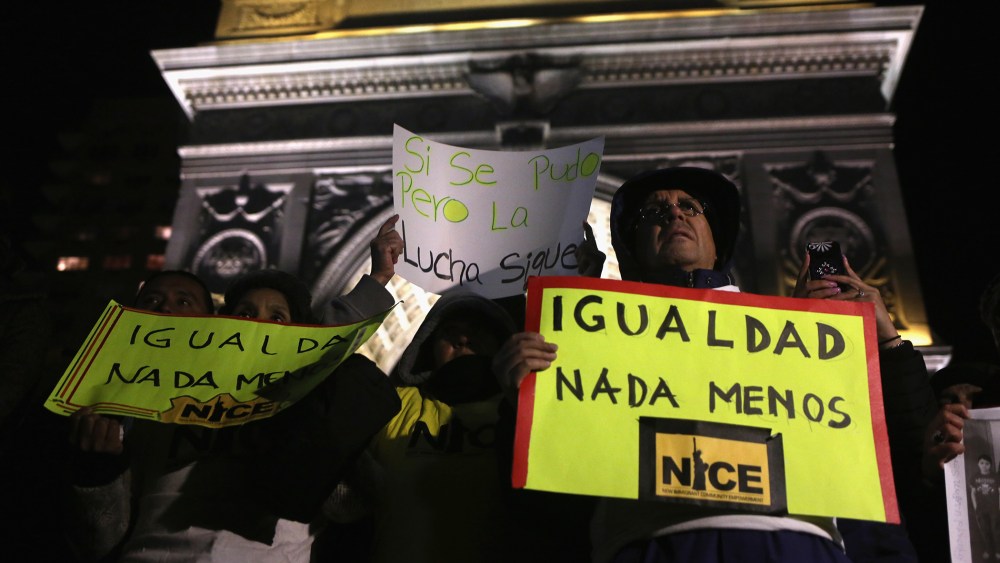 An activist holds a sign during a gathering to celebrate President Barack Obama's executive action on immigration policy in New York, N.Y., on Nov. 21, 2014. (Photo by John Moore/Getty)