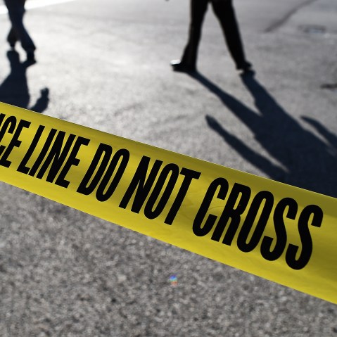 Police officers stand behind crime scene tape. (Photo by Jewel Samad/AFP/Getty)