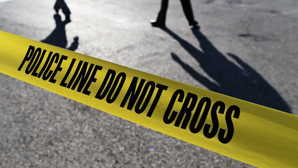 Police officers stand behind crime scene tape. (Photo by Jewel Samad/AFP/Getty)