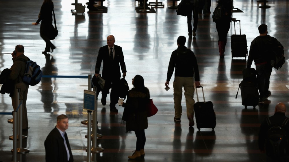Travelers arrive at an airport. (Photo by Alex Wong/Getty)