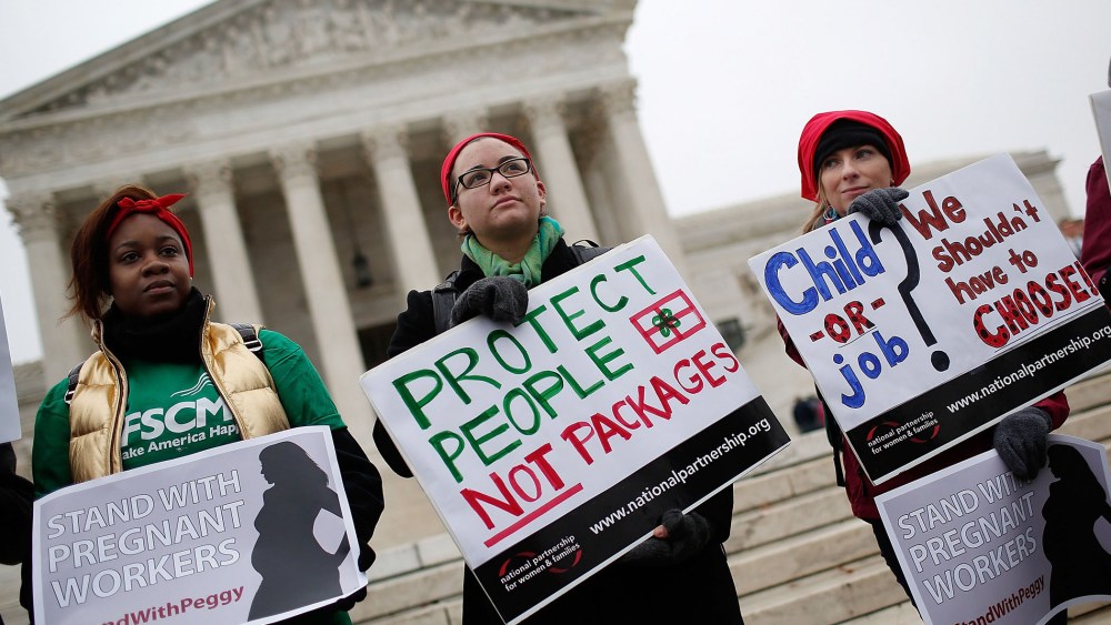 Protesters gather outside the U.S. Supreme Court while the court hears arguments in the Young vs. UPS case on Dec. 3, 2014 in Washington, DC.