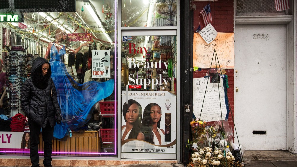 People stand around outside the beauty salon where Eric Garner was killed on July 17, Dec. 3, 2014 in the Staten Island borough of New York, N.Y. (Photo by Andrew Burton/Getty)