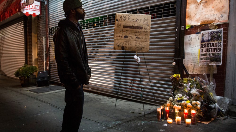 A man pauses at an makeshift memorial for Eric Garner, the man killed by a police officer in July using a chokehold, outside the beauty salon where the confrontation took place, on Dec, 3, 2014 in Staten Island. (Andrew Burton/Getty)