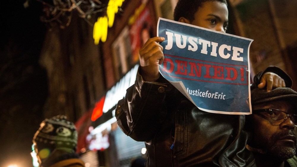 Demonstrators hold an impromptu vigil for Eric Garner, the man killed by a police officer in July using a chokehold, outside the beauty salon where the confrontation took place on Dec. 3, 2014 in the Staten Island borough of New York City.