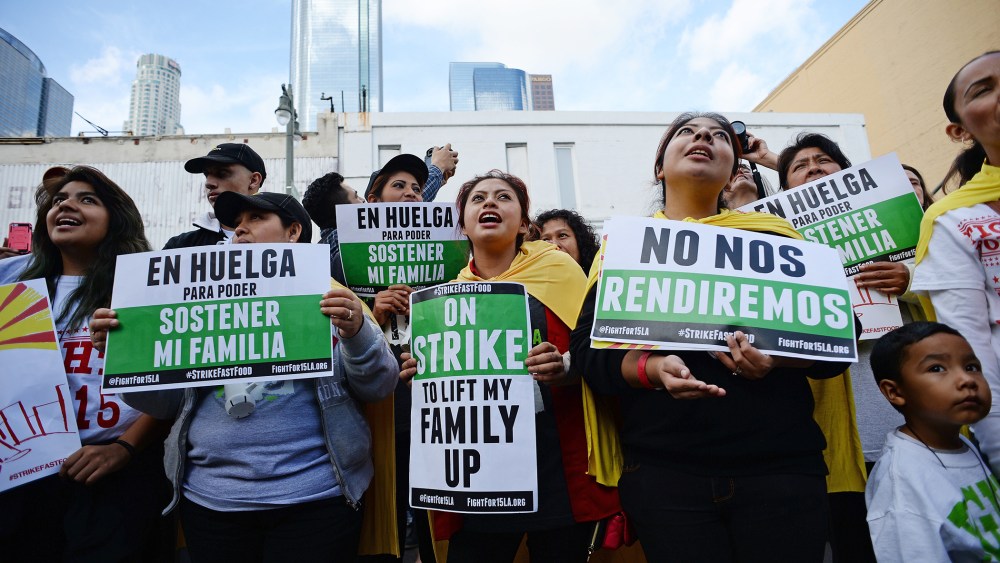 Fast food workers, healthcare workers and their supporters shout slogans at a rally and march to demand an increase of the minimum wage in Los Angeles, Calif. on Dec. 4, 2014. (Photo by Robyn Beck/AFP/Getty)