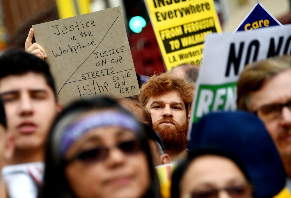 Fast food workers, healthcare workers and their supporters shout slogans at a rally and march to demand an increase of the minimum wage to 15USD per hour, in Los Angeles on Dec. 4, 2014. (Photo by Robyn Beck/AFP/Getty)