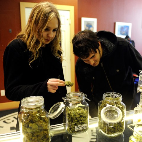 Austin Labry and Kelsey K. check out the selection of wax and shatters at Denver Kush Club, Jan. 1, 2014.