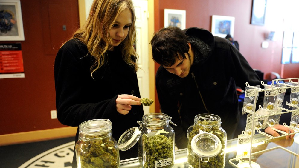 Austin Labry, right, and Kelsey K. from New Orleans, Louisiana check out the selection of wax and shatters at Denver Kush Club, Jan. 1, 2014, in Denver, Colo.