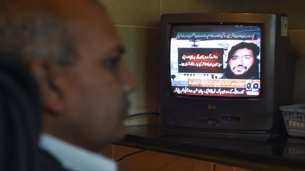 A Pakistani man watches a television broadcasting news of top Al-Qaeda leader Adnan El Shukrijumah, in Islamabad on Dec. 6, 2014. (Farooq Naeem/AFP/Getty)