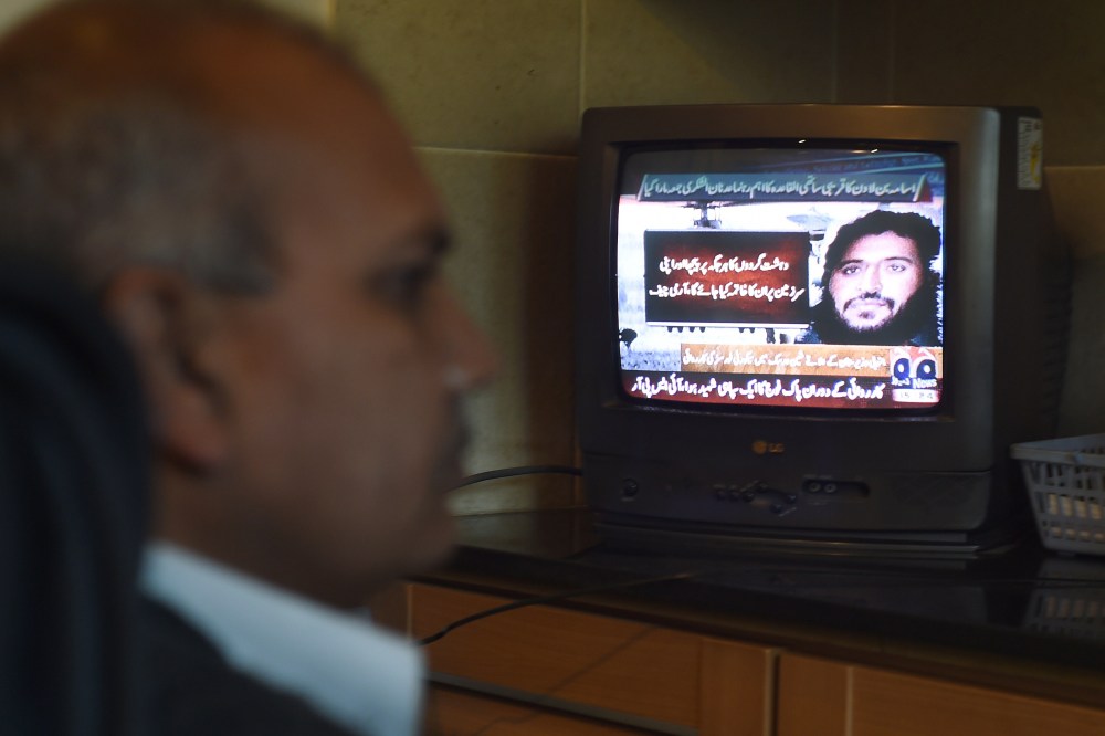 A Pakistani man watches a television broadcasting news of top Al-Qaeda leader Adnan El Shukrijumah, in Islamabad on Dec. 6, 2014. (Farooq Naeem/AFP/Getty)