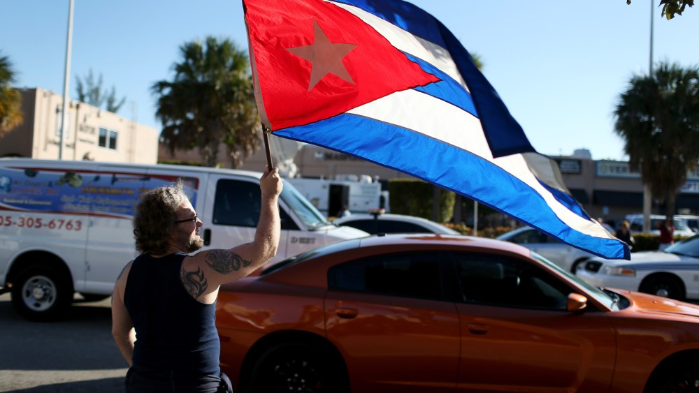 Abdel Rodriguez holds a Cuban flag as he stands outside the Little Havana restaurant Versailles on Dec. 17, 2014 in Miami, Fla. (Joe Raedle/Getty)