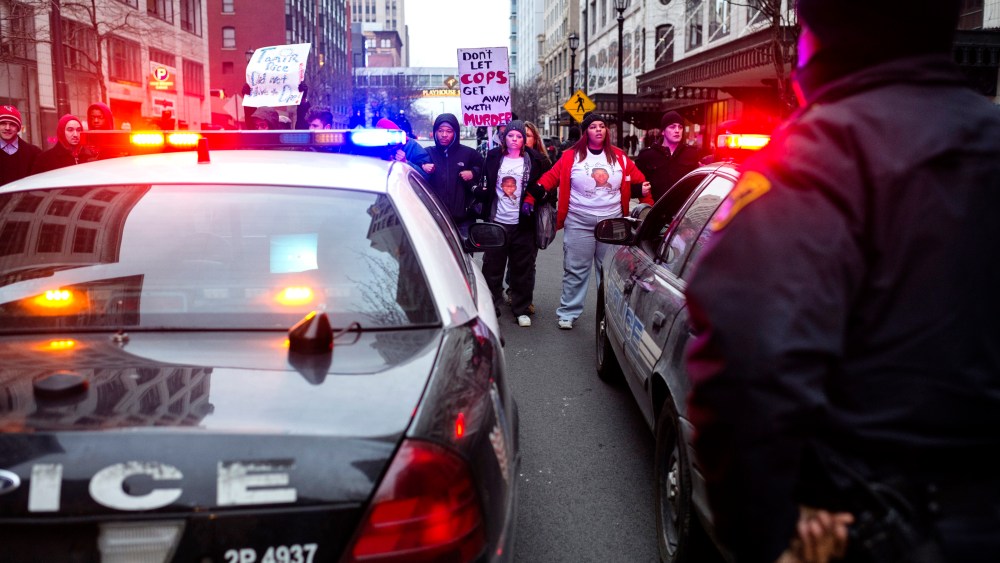 Demonstrators lock arms and block two police cruisers on Ontario Street Dec. 21, 2014, in Cleveland, Ohio. Demonstrators from Ferguson travelled to Cleveland to unite with activists protesting the death of Tamir Rice. (Photo by Angelo Merendino/Getty)