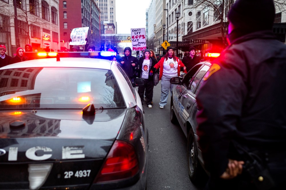 Demonstrators lock arms and block two police cruisers on Ontario Street Dec. 21, 2014, in Cleveland, Ohio. Demonstrators from Ferguson travelled to Cleveland to unite with activists protesting the death of Tamir Rice. (Photo by Angelo Merendino/Getty)