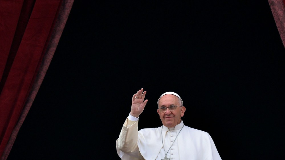 Pope Francis salutes as he gives his traditional Christmas "Urbi et Orbi" blessing from the balcony of St. Peter's Basilica on Dec. 25, 2014 at the Vatican.