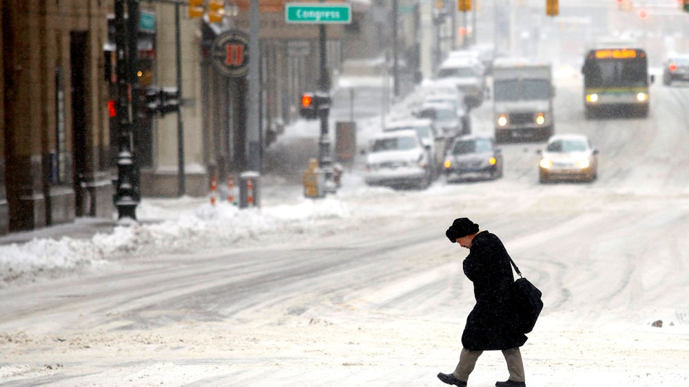 A man navigates through several inches of snow as the area deals with record breaking freezing weather Jan. 6, 2014 in Detroit, Mich.