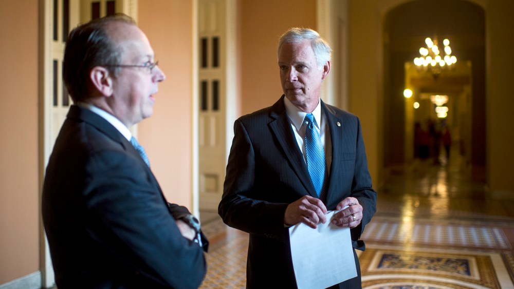 From left, Paul Clement, former United States Solicitor General, and Sen. Ron Johnson, R-Wisc., talk in the hallway before the start of their news conference on Jan. 6, 2014, to announce a lawsuit against the Office of Personnel Management challenging an