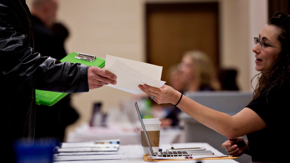 A job seeker talks to a potential employer during a Princeton Area Chamber of Commerce job fair in Princeton, Ill. on Jan. 5, 2015.
