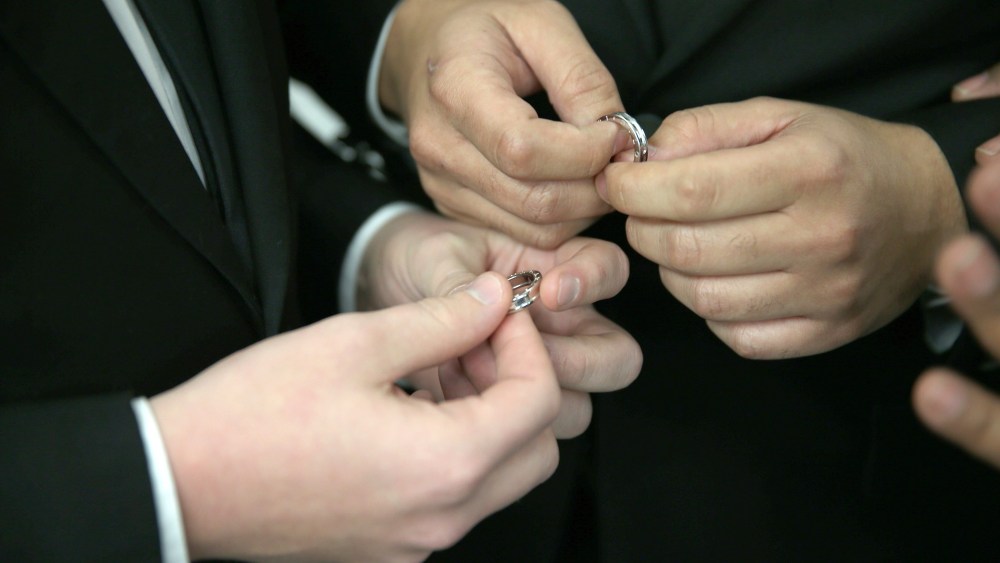 A couple exchange rings as they are wed during a wedding ceremony. (Photo by Joe Raedle/Getty)