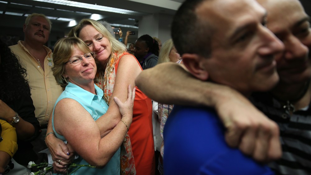 Couples embrace as they attend a wedding ceremony at the Broward County Courthouse on Jan. 6, 2015 in Fort Lauderdale, Fla. (Photo by Joe Raedle/Getty)