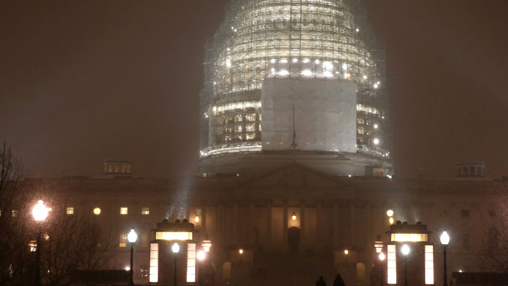 People walk in the falling snow in front of the US Capitol, on Jan. 6, 2015 in Washington, DC.