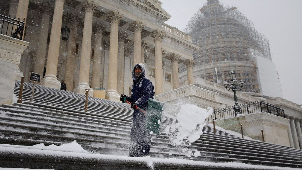 Clearing a path for Congress, an employee of the Architect of the Capitol shovel snow off the steps of the U.S. House of Representatives as more snow continues to fall on Jan. 6, 2015 in Washington, DC. (Photo by Chip Somodevilla/Getty)