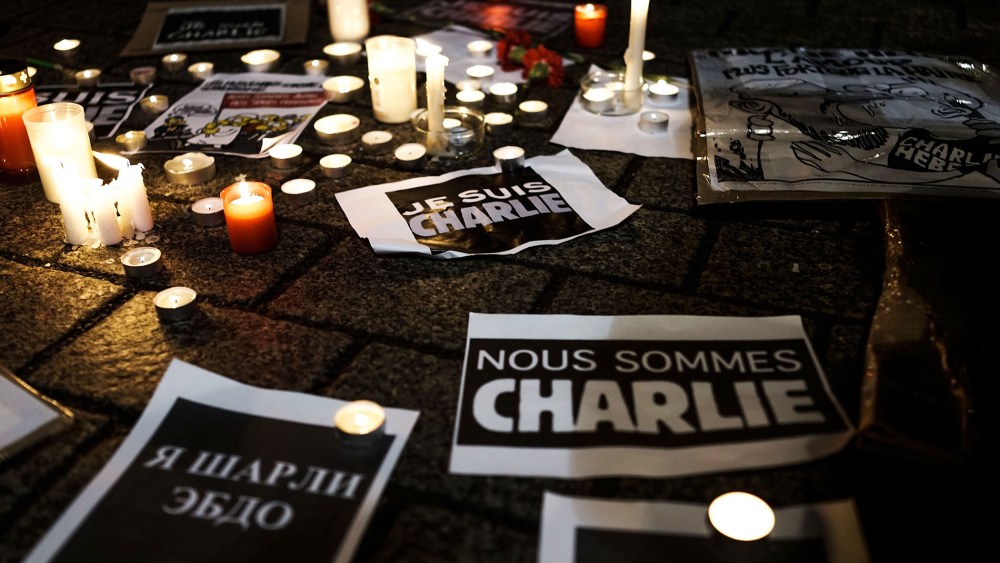 Papers with the written words "We are Charlie" lie on the ground while people gather at a vigil in front of the French Embassy following the terrorist attack in Paris on Jan. 7, 2015 in Berlin, Germany. (Photo by Carsten Koall/Getty)