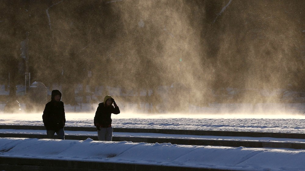 People are windblown as they walk near the frozen reflecting pool in front of the U.S. Capitol on Jan. 7, 2015 in Washington, DC. The Washington area is experiencing heavy winds with temperatures in the teens. (Mark Wilson/Getty Images)