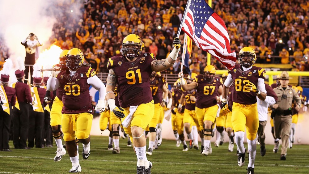 Arizona State Sun Devils players run out onto the field before a game against the Stanford Cardinals at Sun Devil Stadium on December 7, 2013.