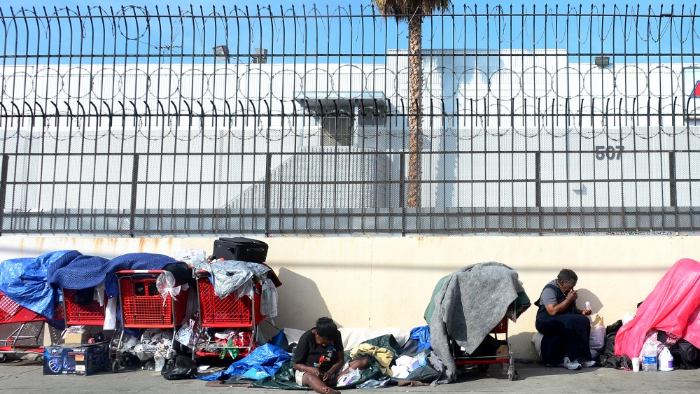 Homeless women sit amid their belongings on a street in downtown Los Angeles, California, on January 8, 2014.