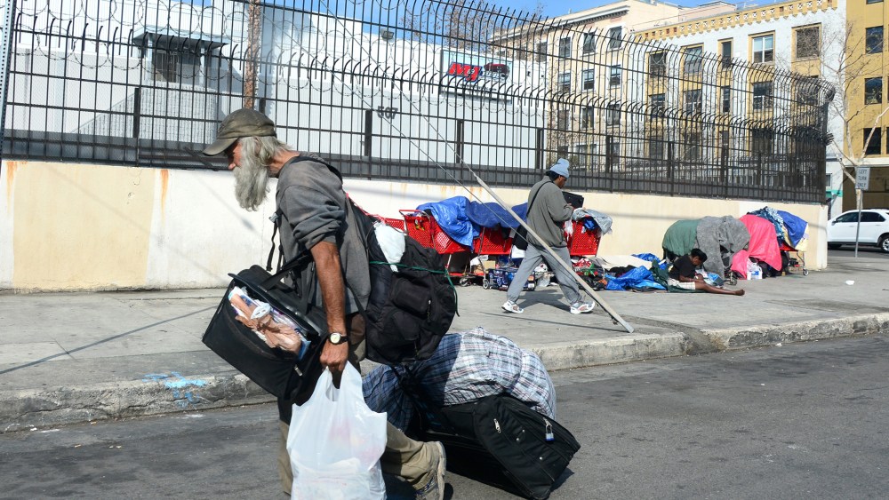 A homeless man carries his belongings in downtown Los Angeles, California, on January 8, 2014.