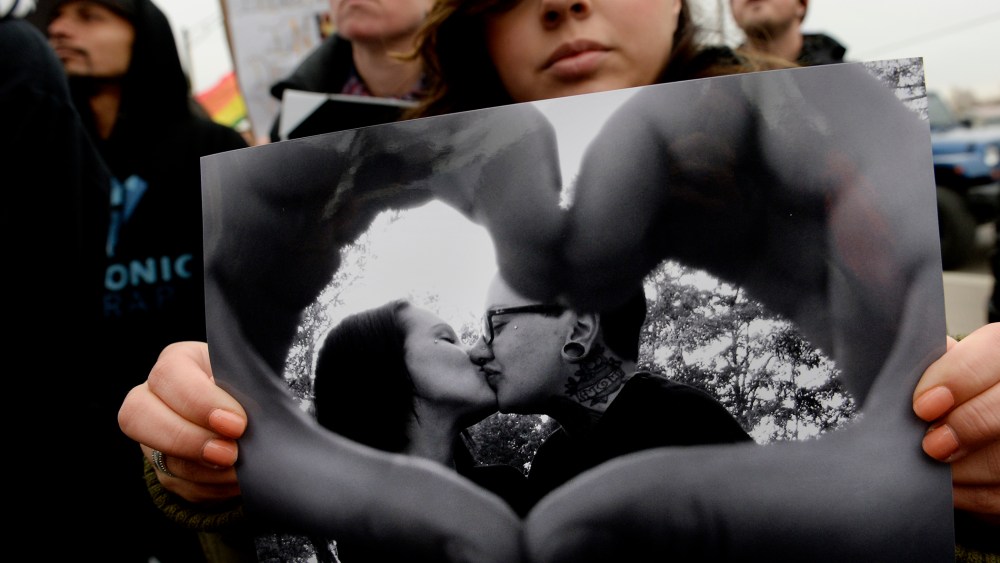 Victoria Quintana carries a photograph of Vanessa Collier, right, and her partner, Christina Higley, during a rally outside New Hope Ministries in Lakewood, Colo. on Jan. 13, 2015. (Photo by Craig F. Walker/The Denver Post/Getty)