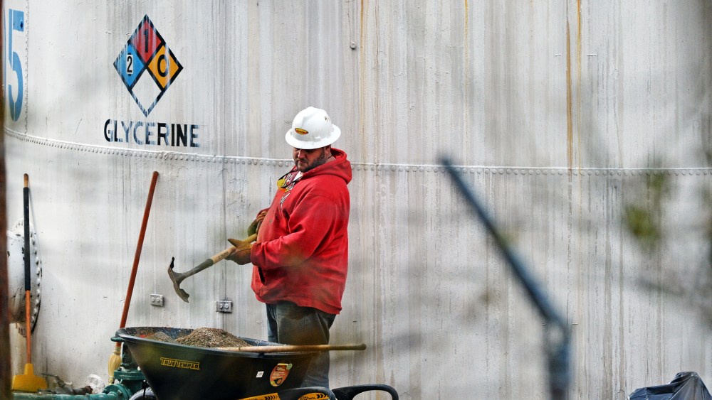 An unidentified worker at Freedom Industries shovels NAPA premium oil absorbent in Charleston, West Virginia, Jan. 10, 2014.