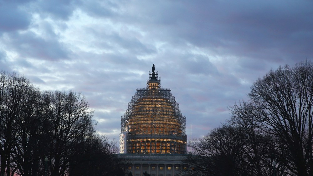 The early morning sun begins to rise behind the U.S. Capitol building on Jan. 20, 2015 in Washington, DC. (Photo by Mark Wilson/Getty)