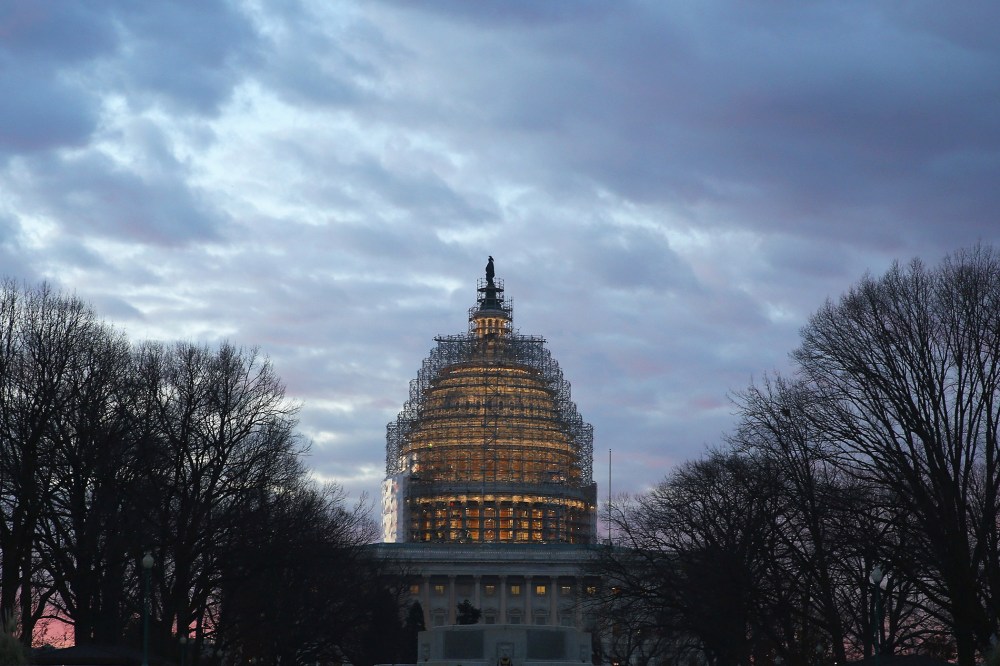 The early morning sun begins to rise behind the U.S. Capitol building on Jan. 20, 2015 in Washington, DC. (Photo by Mark Wilson/Getty)