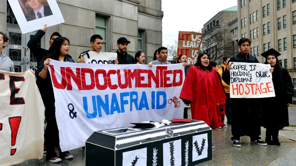 Immigration activists chant behind a cardboard coffin on the front steps of the North Carolina Attorney General's office in Raleigh, N.C., Jan. 11, 2014. (Photo by Chuck Liddy/Raleigh News & Observer/MCT)