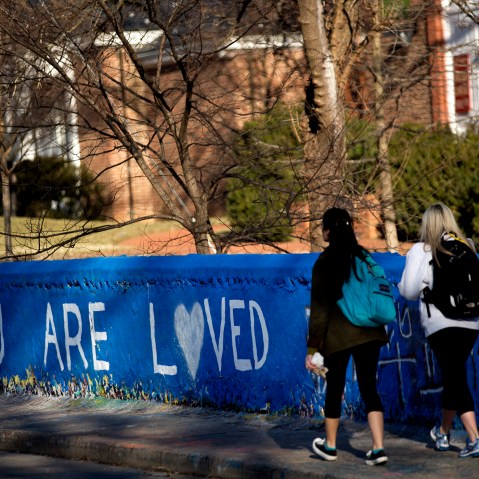 Students walk past the message "You are Loved" painted on a wall next to the Beta Bridge near the University of Virginia campus in Charlottesville, Va. on Jan. 16, 2015.