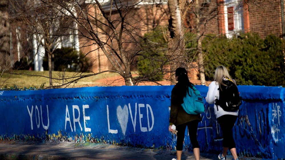 Students walk past the message "You are Loved" painted on a wall next to the Beta Bridge near the University of Virginia campus in Charlottesville, Va. on Jan. 16, 2015.
