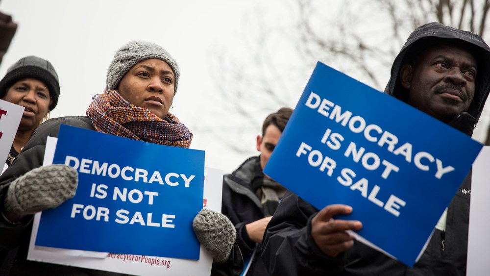 Attendees hold signs during a rally calling for an end to corporate money in politics and to mark the fifth anniversary of the Supreme Court's Citizens United decision on Jan. 21, 2015 in Washington, D.C. (Photo by Drew Angerer/Getty)