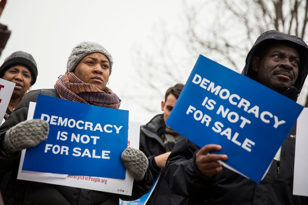 Attendees hold signs during a rally calling for an end to corporate money in politics and to mark the fifth anniversary of the Supreme Court's Citizens United decision on Jan. 21, 2015 in Washington, D.C. (Photo by Drew Angerer/Getty)
