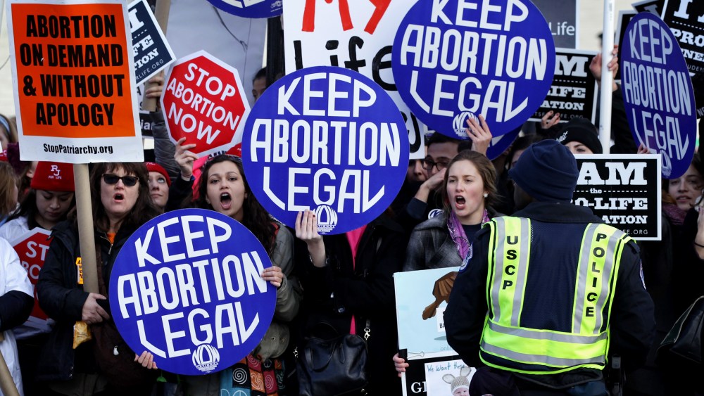 Pro-choice activists shout slogans before the annual March for Life passes by the U.S. Supreme Court, Jan. 22, 2015 in Washington, DC. (Photo by Alex Wong/Getty)