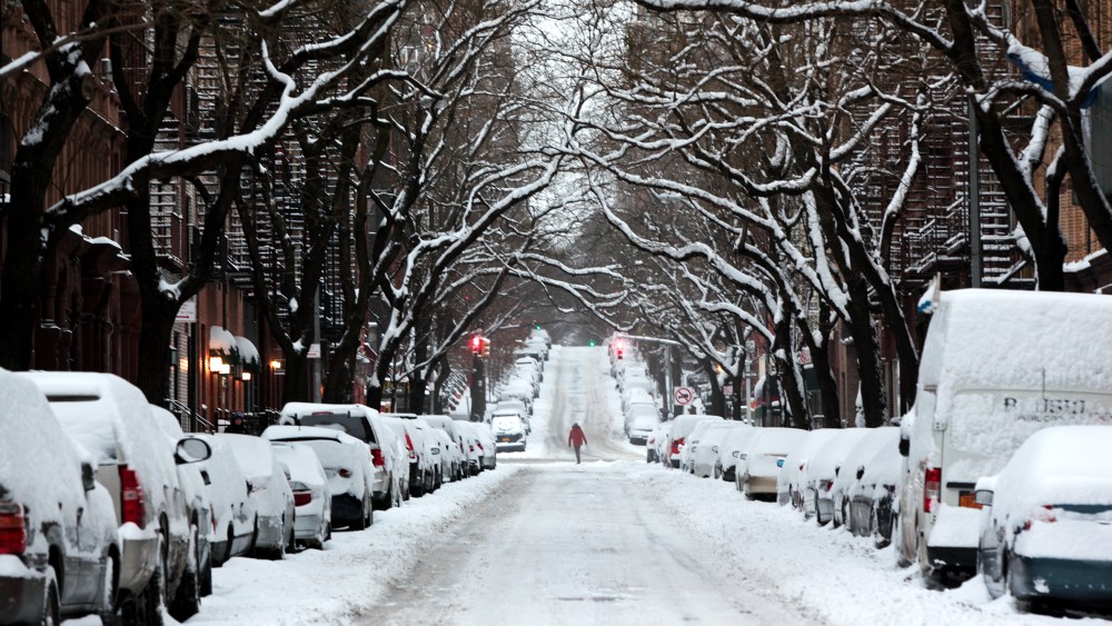 A passerby walks through an accumulation of snow on Jan. 27, 2015 on the Upper East Side of New York. (Photo by Yana Paskova/Getty)
