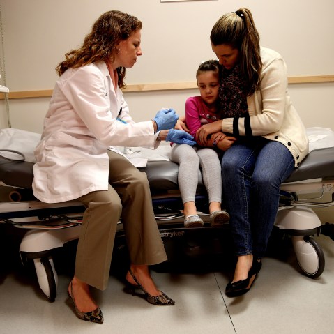Miami Children's Hospital pediatrician Dr. Amanda Porro, M.D prepares to administer a measles vaccination to Sophie Barquin,4, as her mother Gabrielle Barquin holds her on Jan. 28, 2015 in Miami, Florida. (Photo by Joe Raedle/Getty)