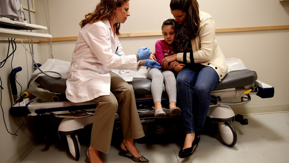 Miami Children's Hospital pediatrician Dr. Amanda Porro, M.D prepares to administer a measles vaccination to Sophie Barquin,4, as her mother Gabrielle Barquin holds her on Jan. 28, 2015 in Miami, Florida. (Photo by Joe Raedle/Getty)