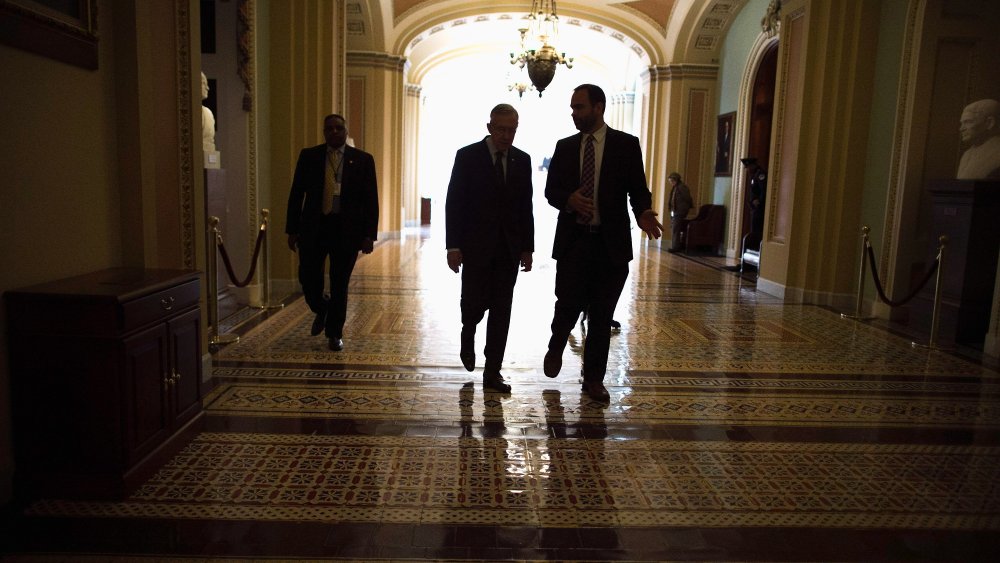 Senate Majority Leader Harry Reid (D-NV) (2nd L) talks with Senior Intelligence and Defense Advisor Tommy Ross (R) while walking through the U.S. Capitol after opening the Senate for the week, January 13, 2014 in Washington, D.C.